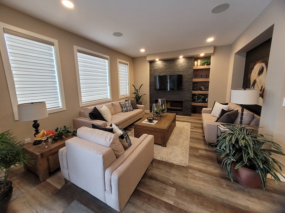 living room with wood floors, white furniture and flatscreen TV